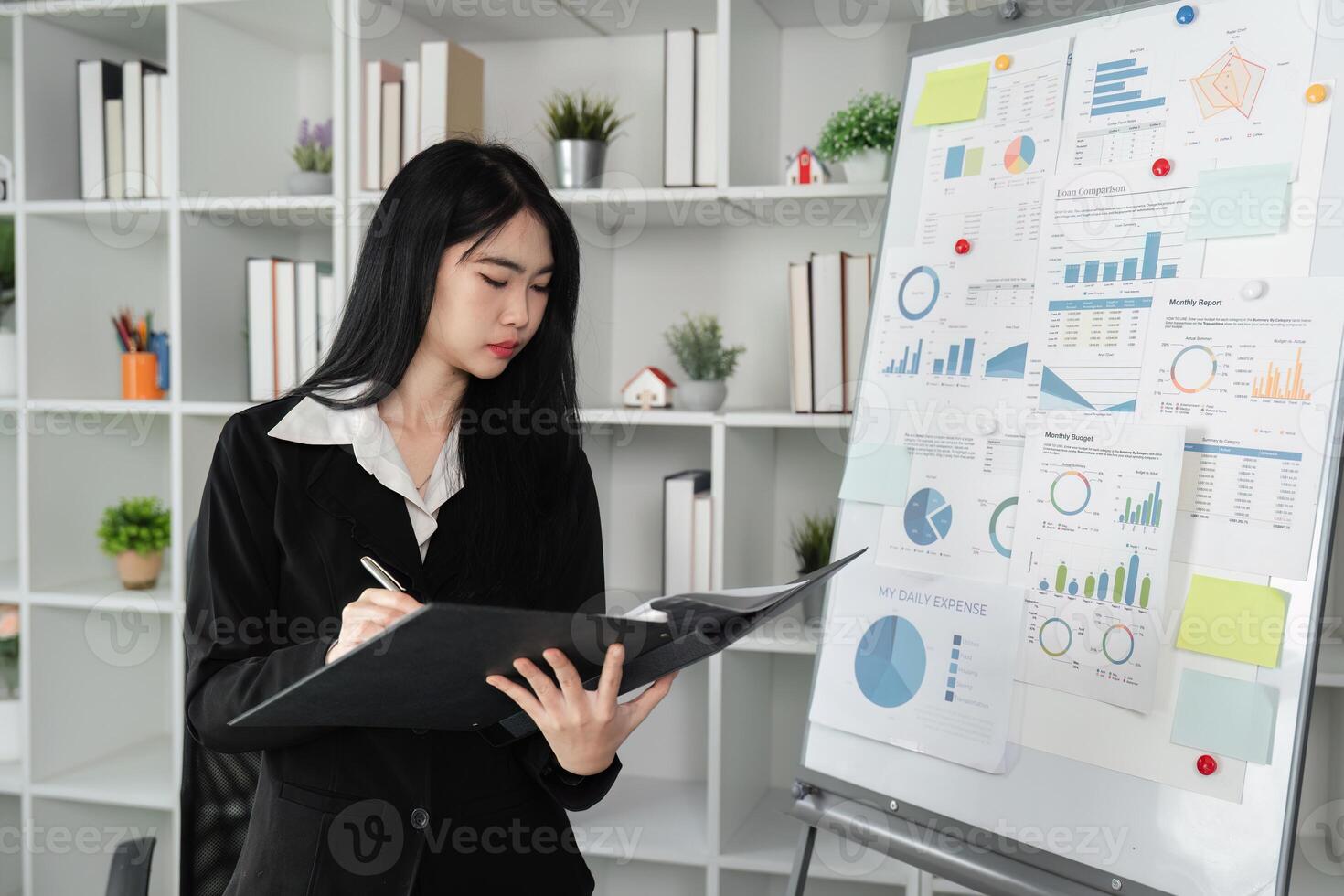 Focused accountant analyzing financial reports and charts in a modern office setting. photo