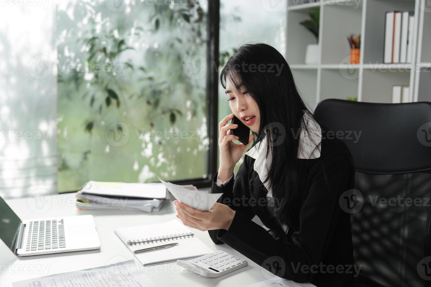 Accountant on the phone discussing financial matters while reviewing documents. photo