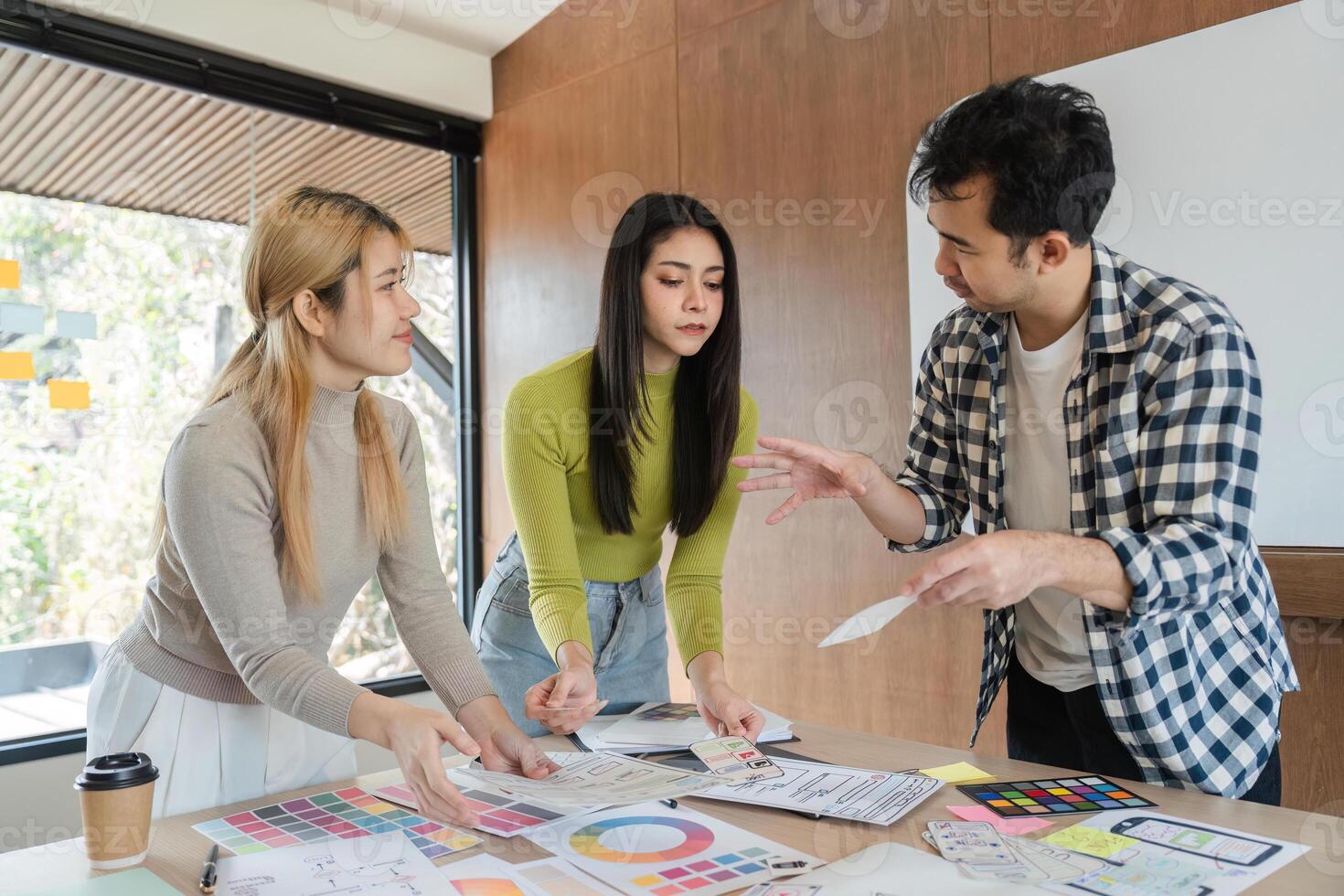 Diverse team collaborating on design concepts and discussing feedback in office. photo