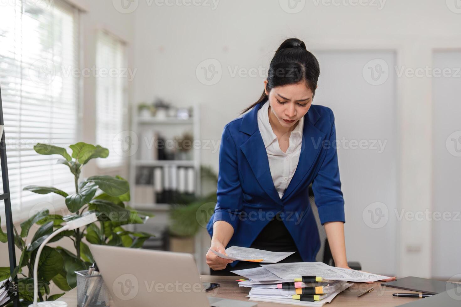 Accountant analyzing financial paperwork in a contemporary workspace, ensuring accurate tax filing. photo