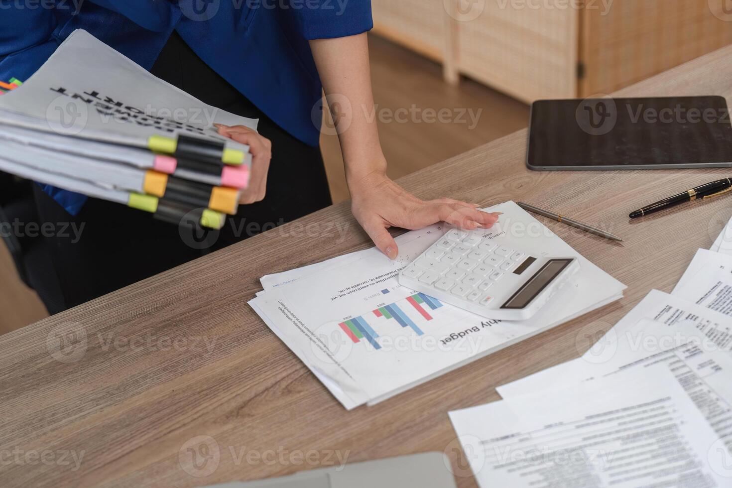 Accountant using calculator for financial analysis in office photo