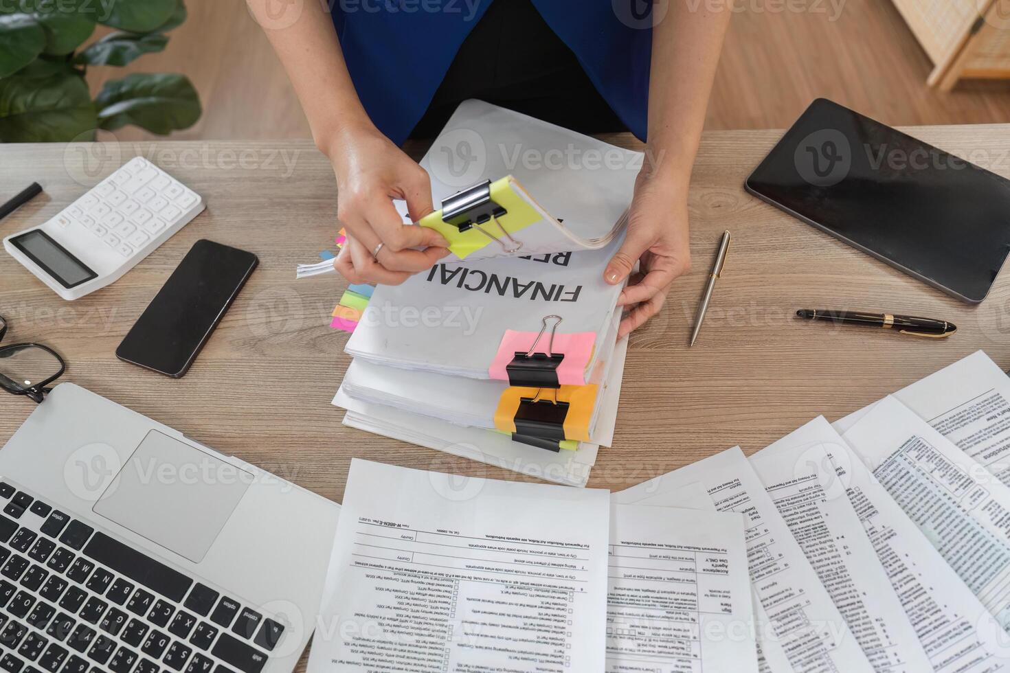 Accountant sorting financial documents and reports at a desk photo