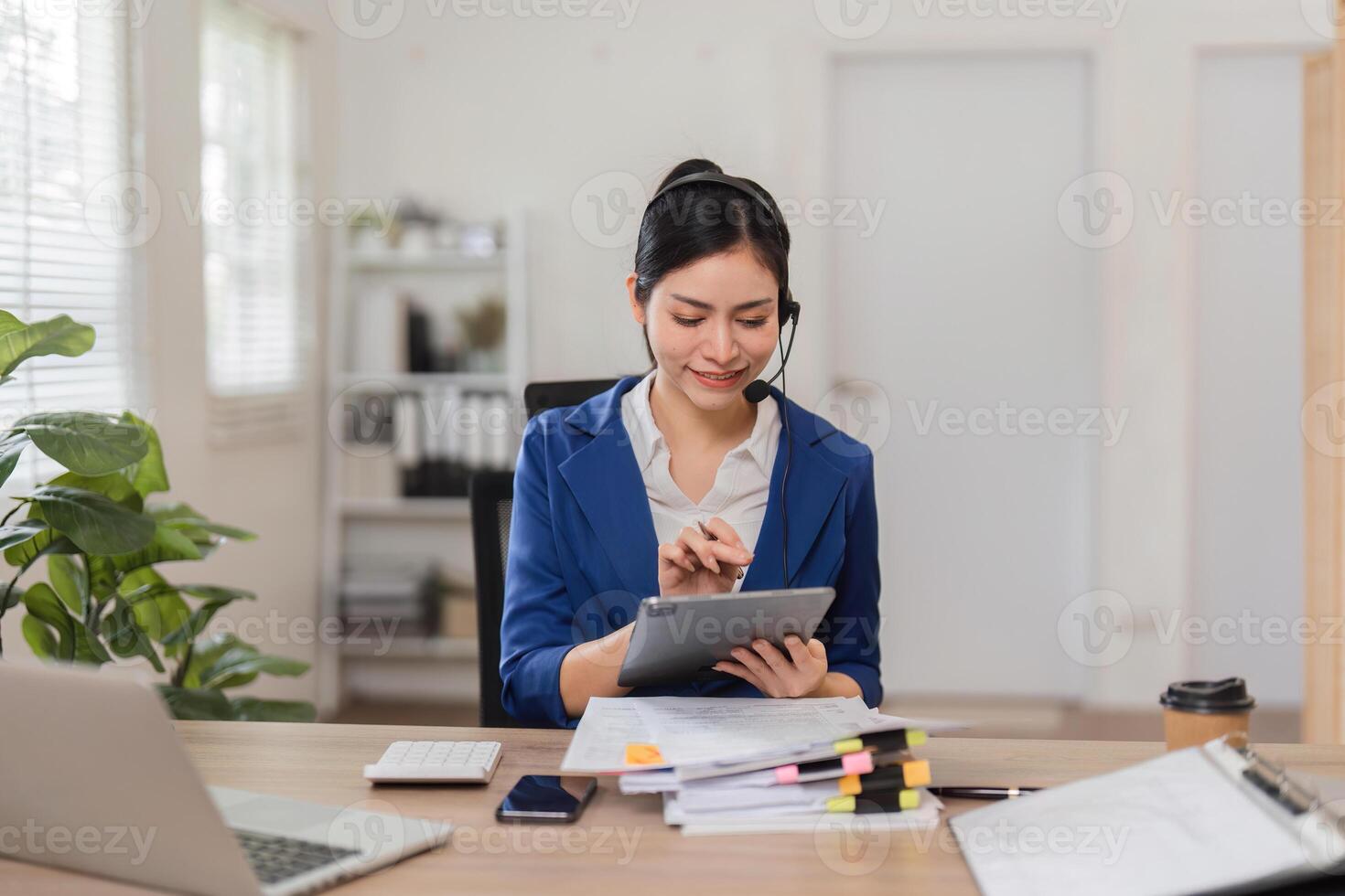 Accountant using a tablet to manage finances and communicate with clients in a bright workspace. photo