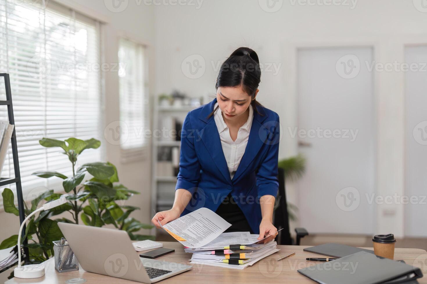 Accountant reviewing tax documents in a modern office, focusing on financial organization and filing. photo