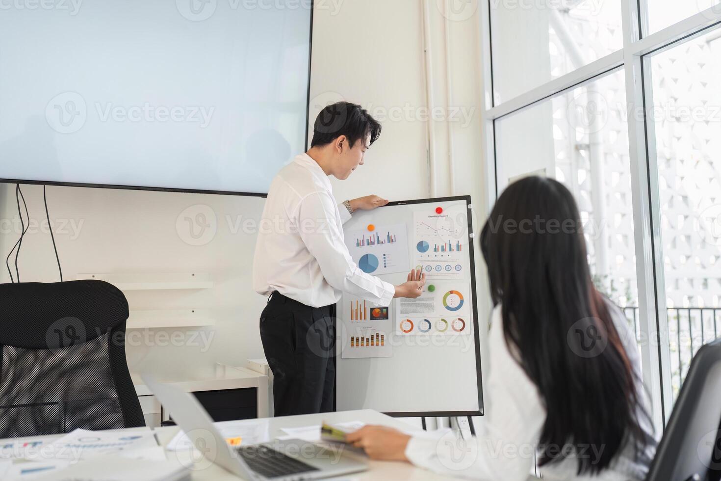 Professional reviewing financial charts and discussing tax strategies with a colleague photo