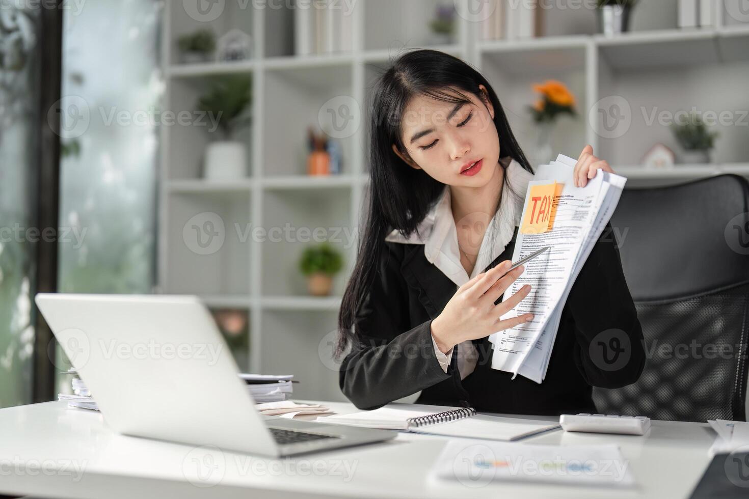 Focused accountant discussing tax strategies with documents in hand at her desk. photo