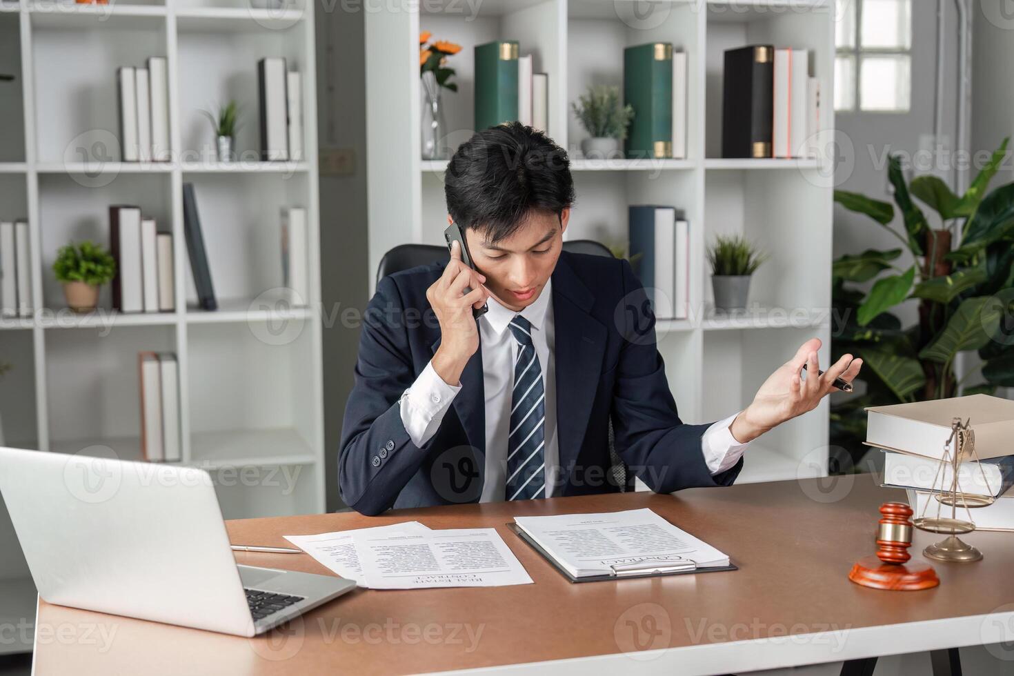 Business lawyer on phone discussing case details, reviewing documents and legal notes in modern office. photo