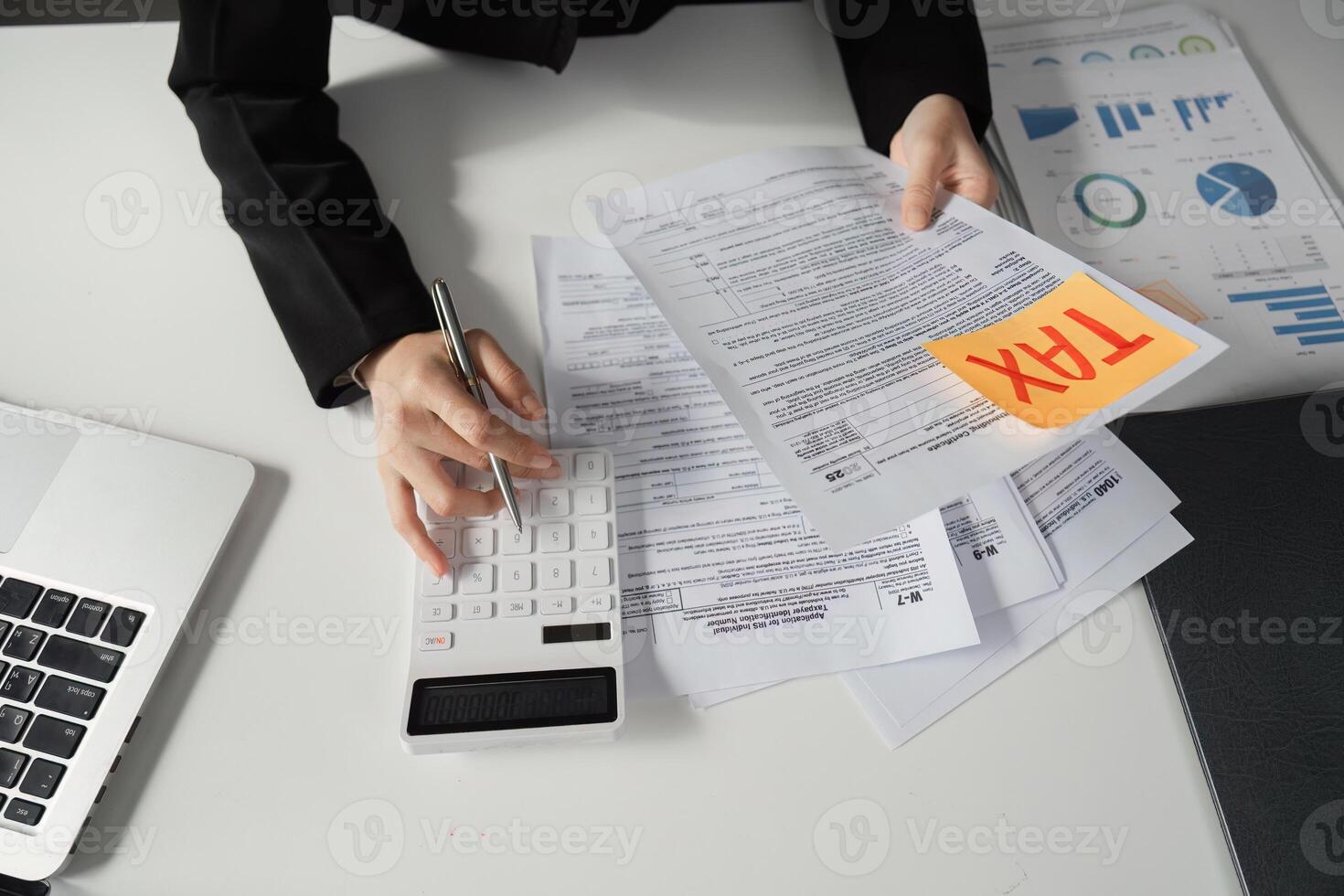 Businesswoman calculating taxes and reviewing financial documents. photo