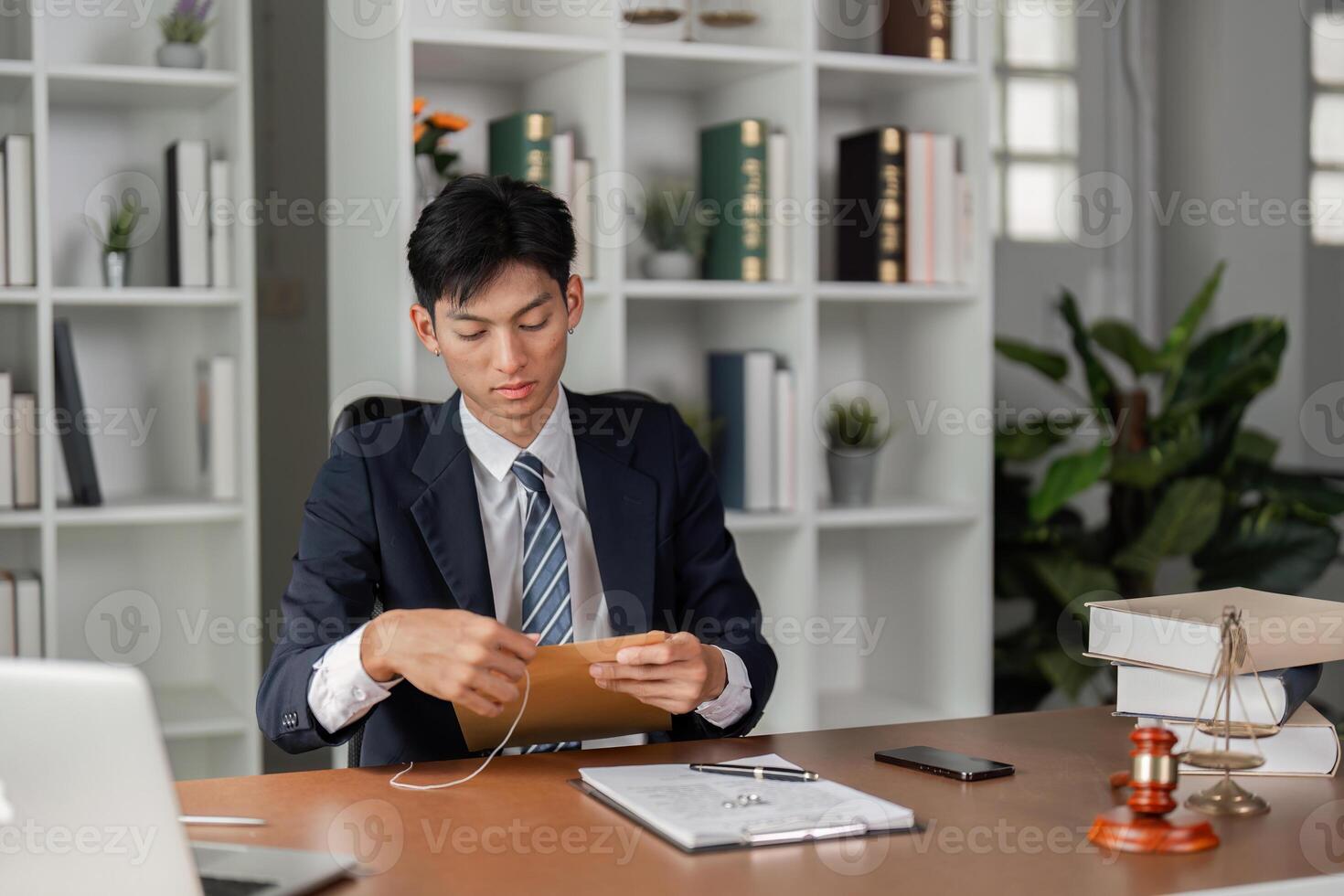 Young businessman reviewing important documents and preparing for tasks in a modern office setting. photo