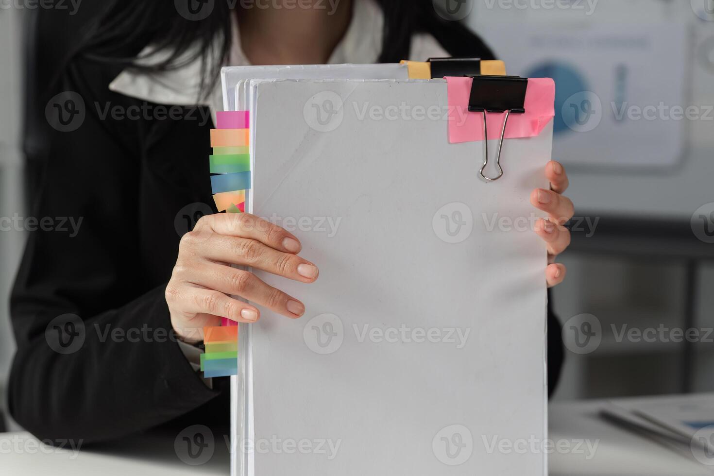 Accountant holding organized financial documents with colorful tabs for easy reference. photo