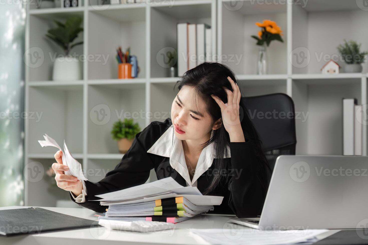 Stressed accountant reviewing financial documents at desk, facing tax filing challenges photo