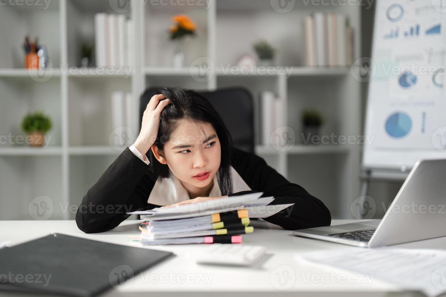 Stressed businesswoman reviewing tax documents at her desk, highlighting financial challenges. photo