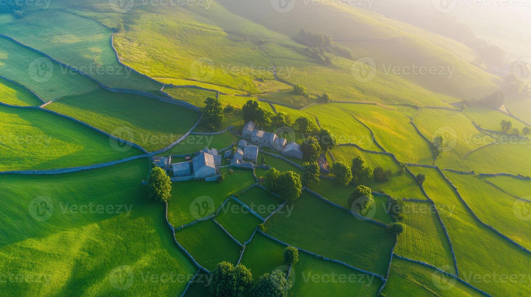 Aerial view of lush green fields and stone farmhouses in countryside landscape photo