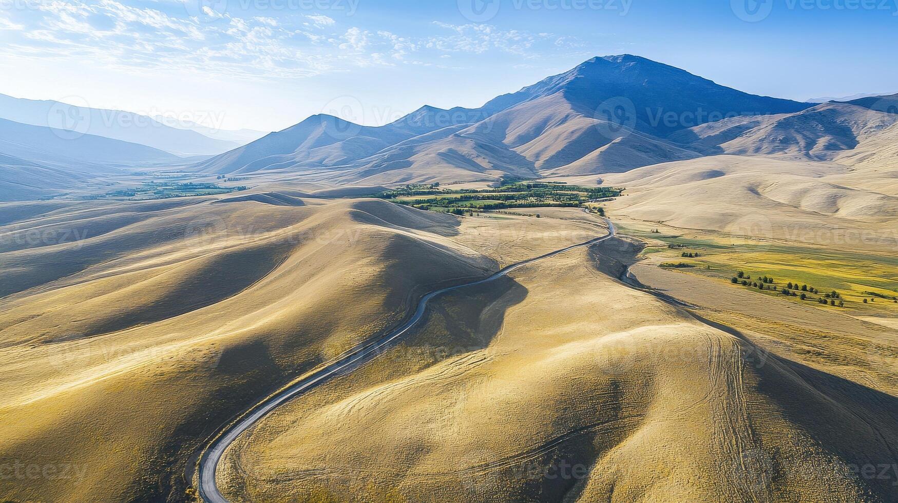 Aerial view of rolling hills and distant mountain under a clear blue sky photo