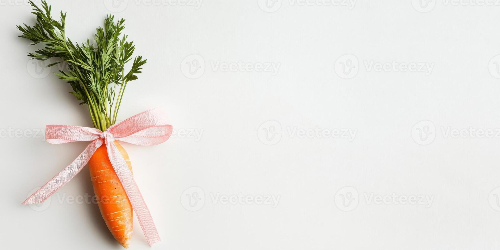 Fresh carrot with green leaves tied by a pink bow on a white background photo