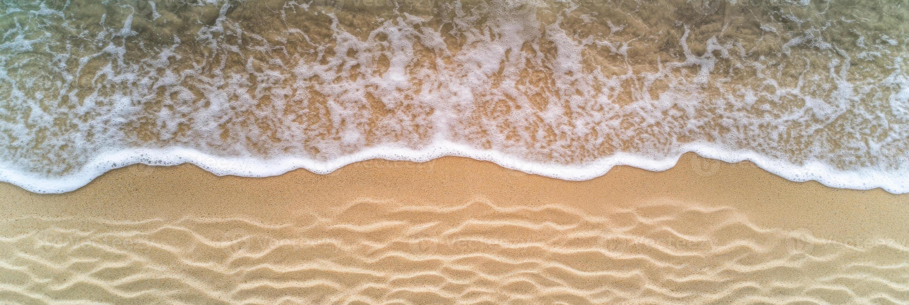 Aerial view of waves gently crashing on sandy beach shoreline pattern photo