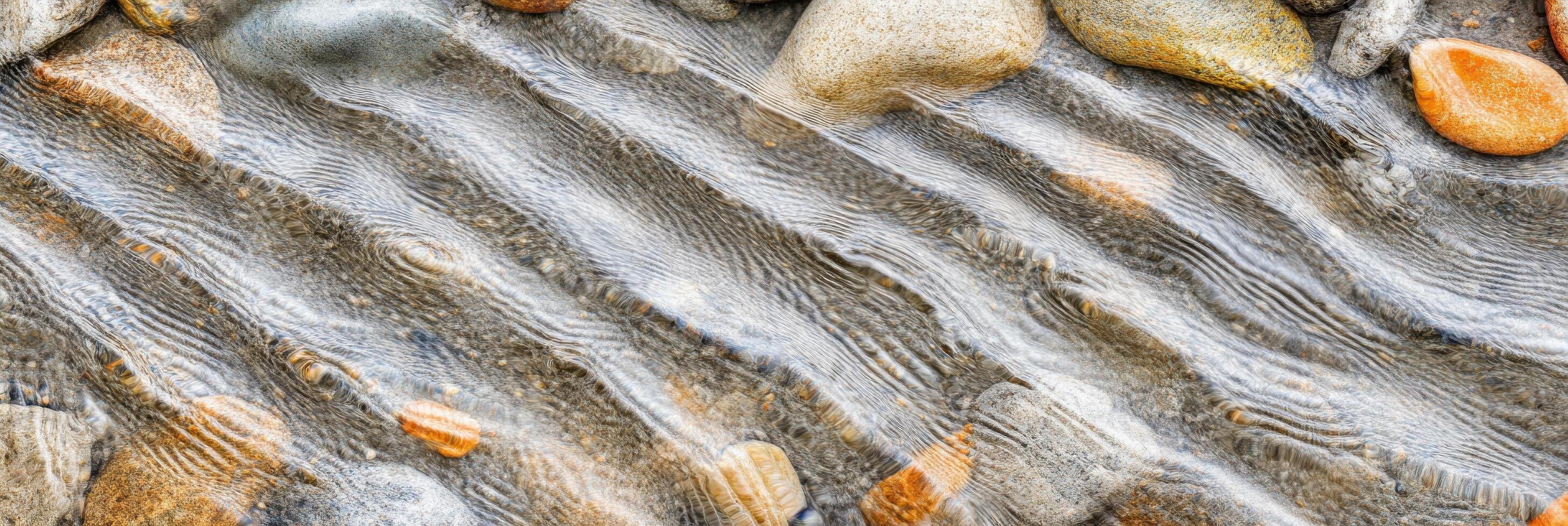 Flowing water over smooth river stones creating a natural texture pattern photo