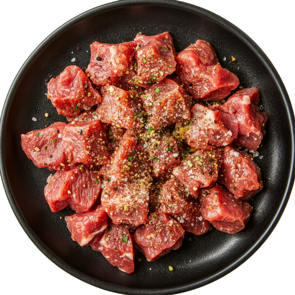Seasoned raw beef cubes arranged artfully on a black plate isolated for culinary presentation, seasoned raw beef food on black plate top view isolated on transparent background png