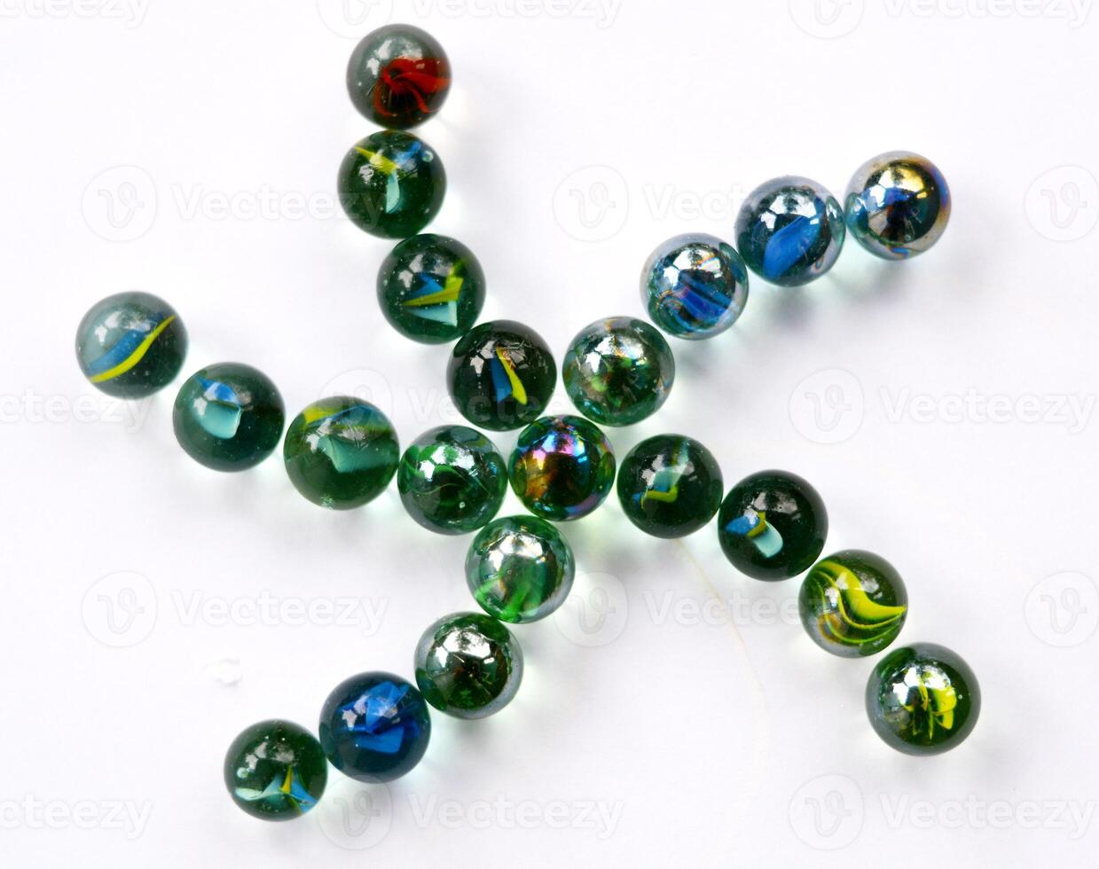 A collection of toy marbles arranged in the shape of a starfish on a white background. art background. Unique art. Unique photo of toy marbles. Toy marbles design.