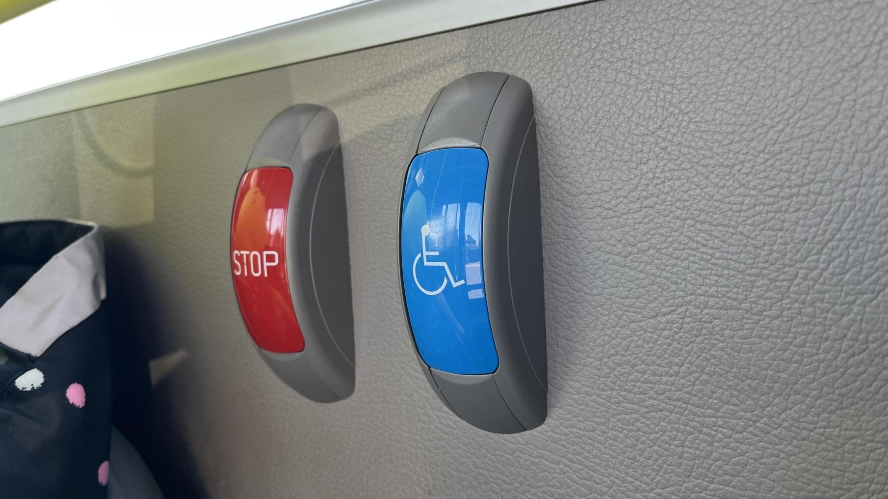 Bus stop request buttons. Red STOP and blue accessibility symbol on a bus interior wall photo
