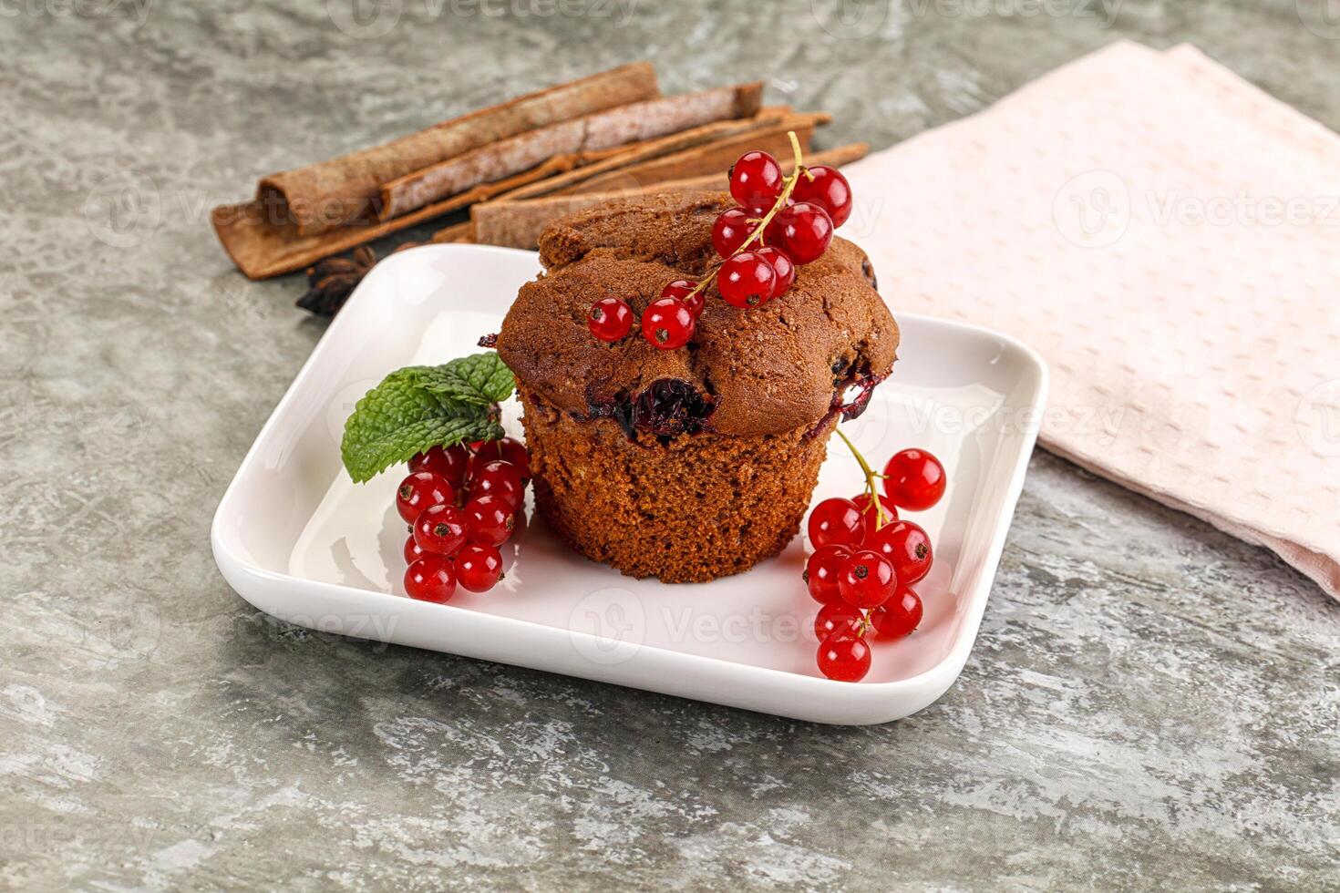A muffin with berries and cinnamon on a plate photo