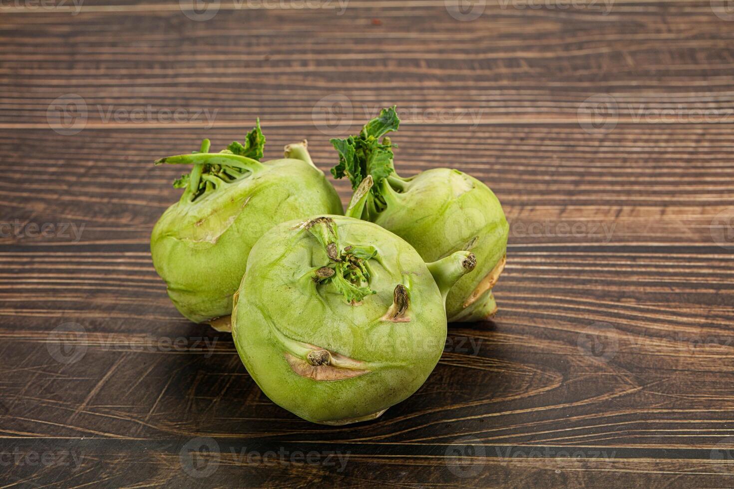 Three green fruits sitting on a wooden table photo