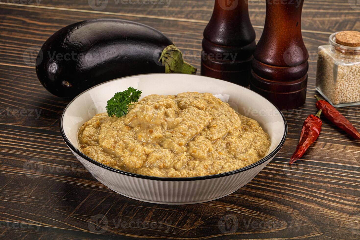 A bowl of hummus with some spices and a pepper photo