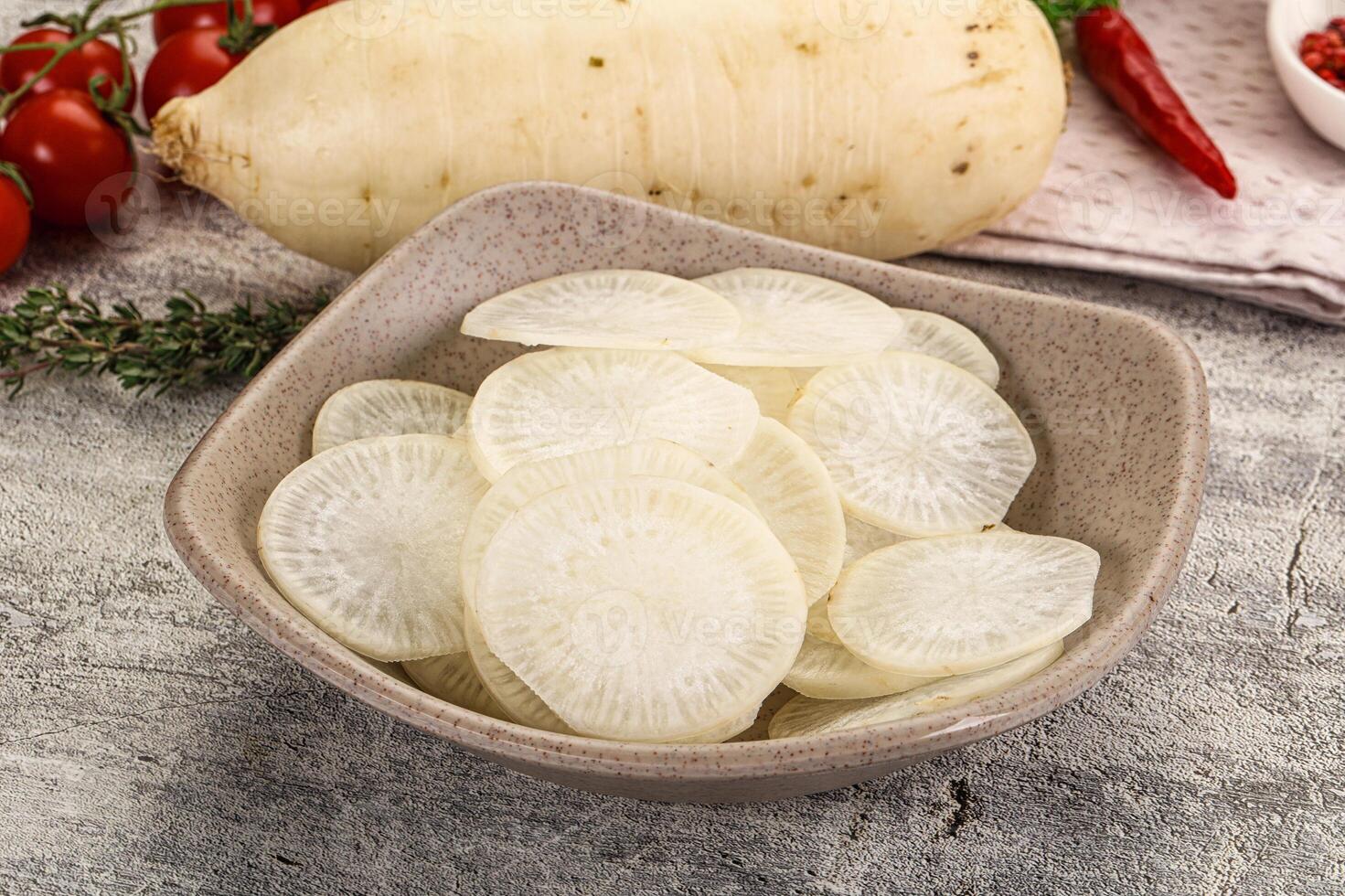 A bowl of sliced white radishes on a table photo
