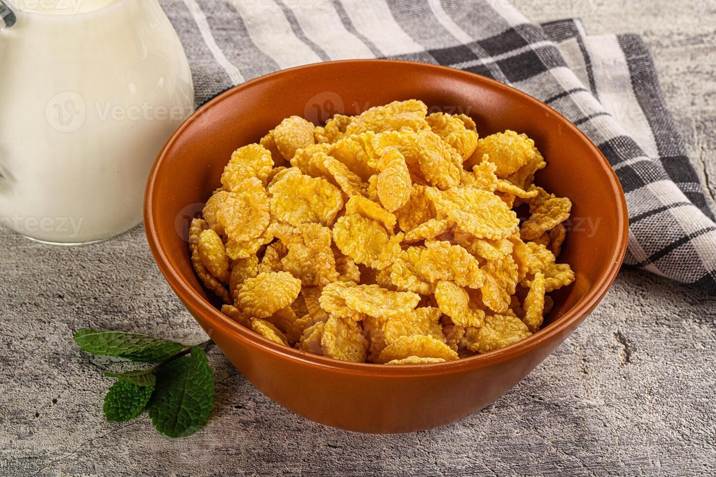Corn flakes and milk on a wooden table photo