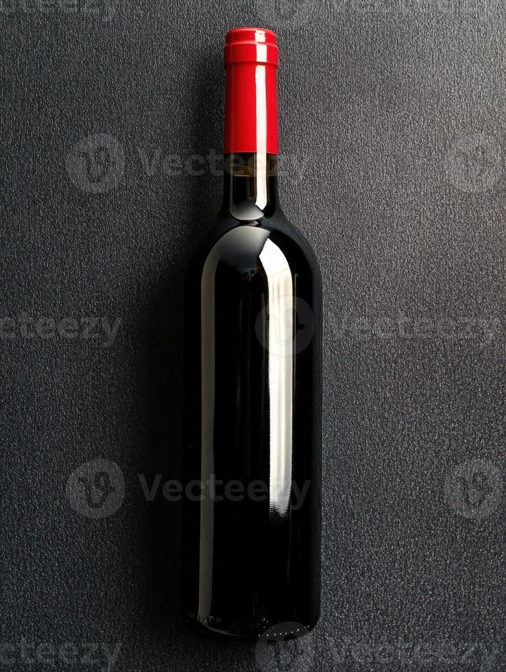 Elegant red wine bottle displayed on a textured surface photo