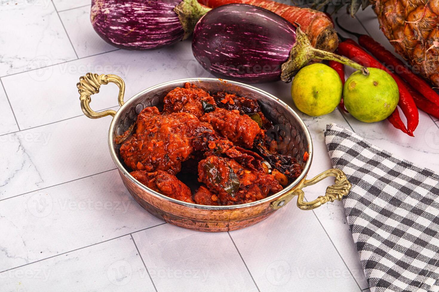 A bowl of food sitting on a counter next to a bunch of vegetables photo