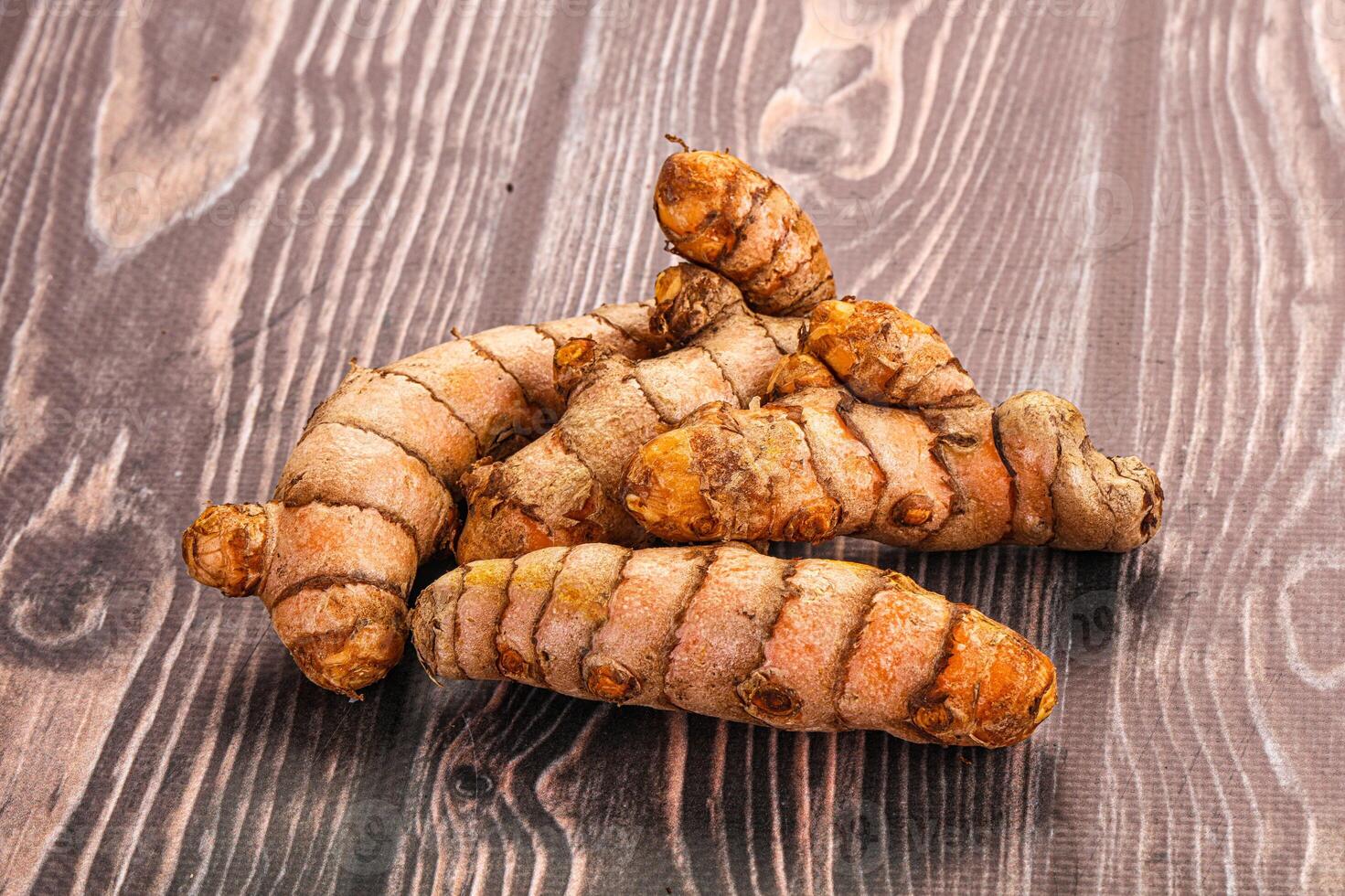 A pile of ginger root on a wooden table photo
