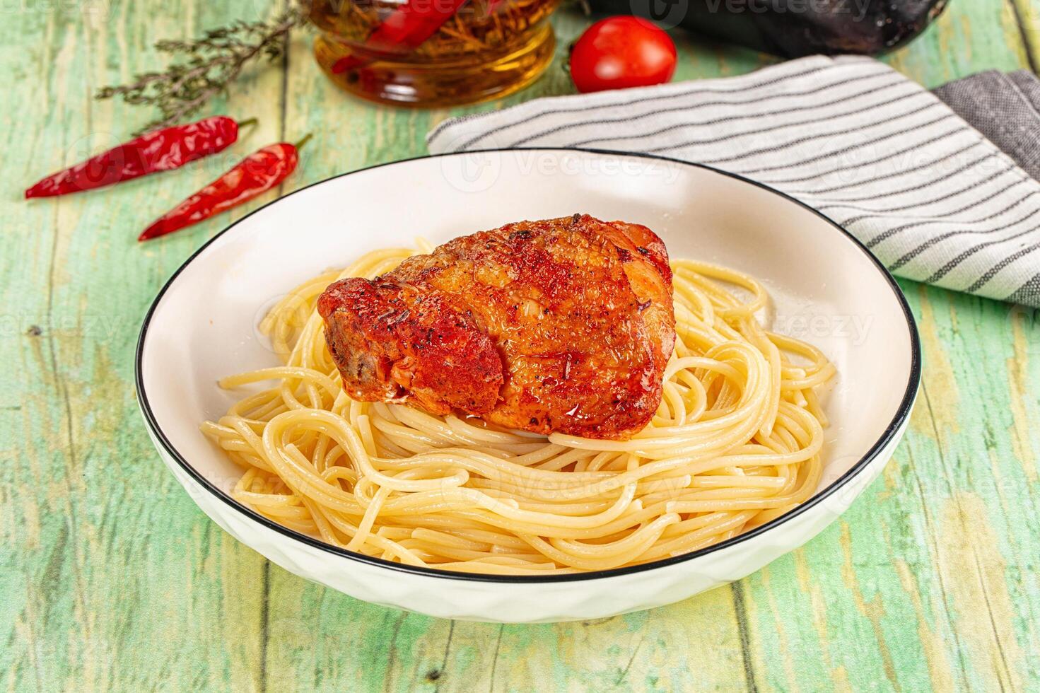 A bowl of pasta and a chicken breast in a white bowl photo