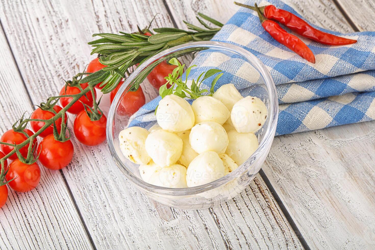 A bowl of cheese and tomatoes on a table photo