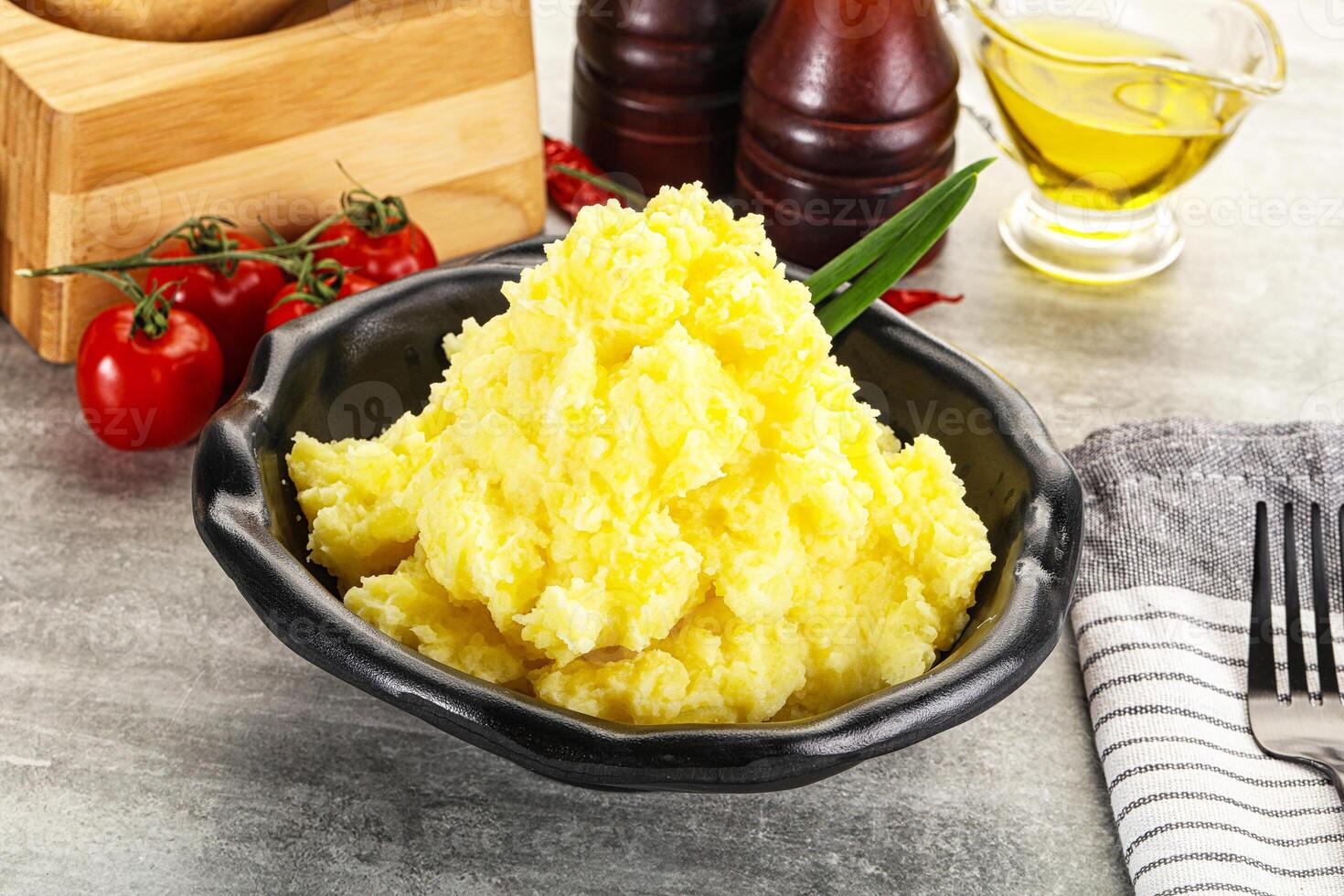 A bowl of mashed potatoes with a knife and fork photo