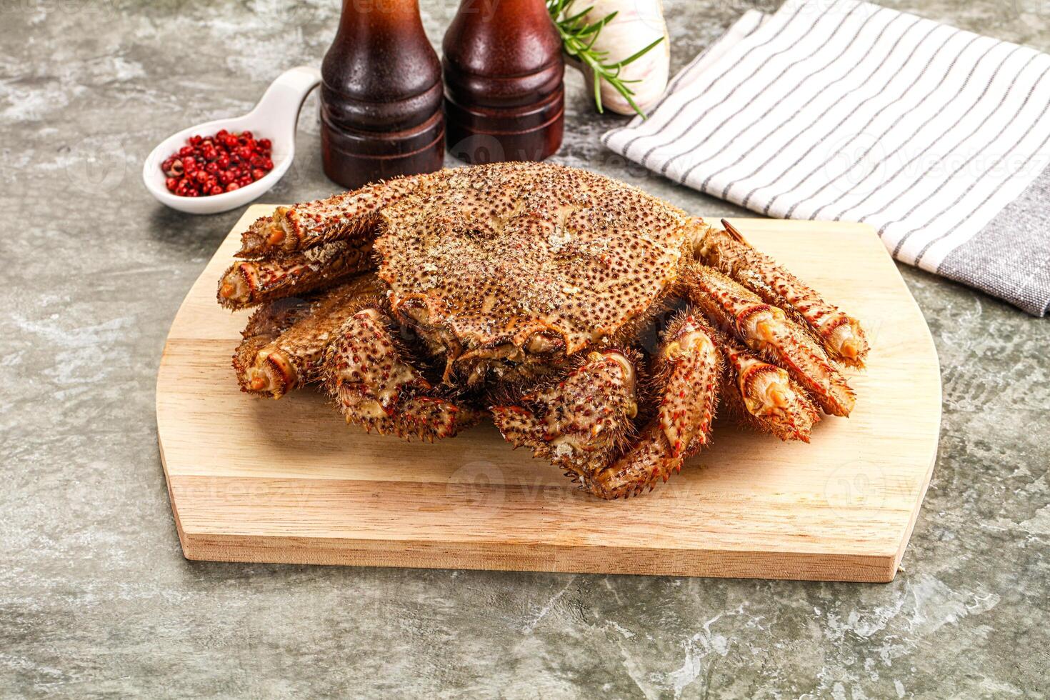 A crab on a cutting board with a bottle of beer and a bottle of ketchup photo