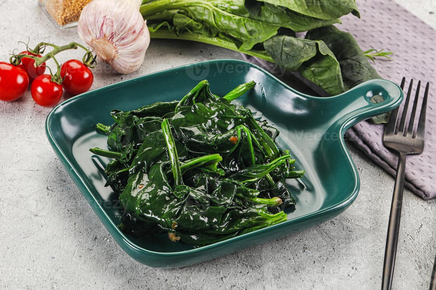 A green dish with spinach and tomatoes photo