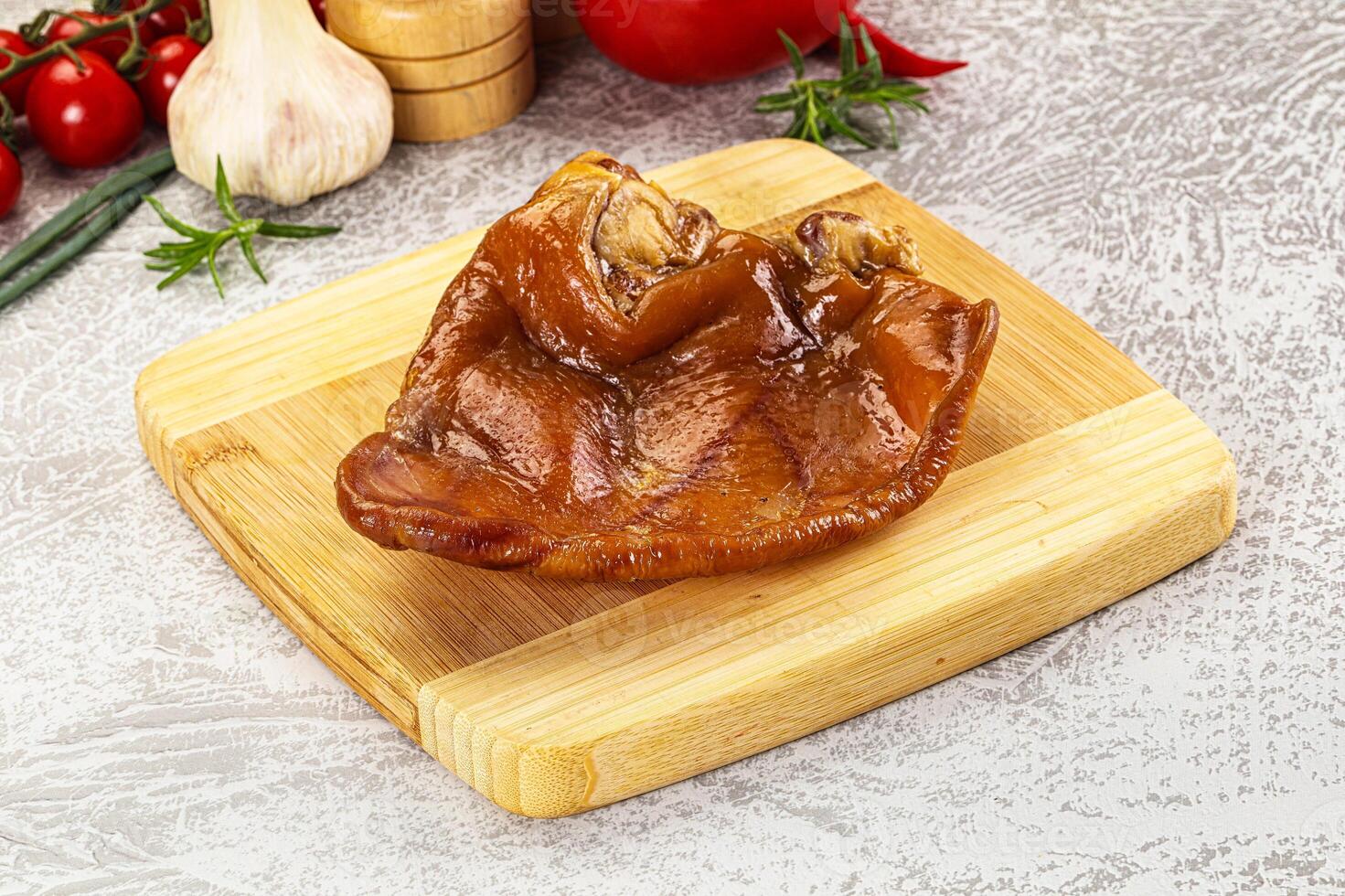 A piece of meat on a cutting board with vegetables photo