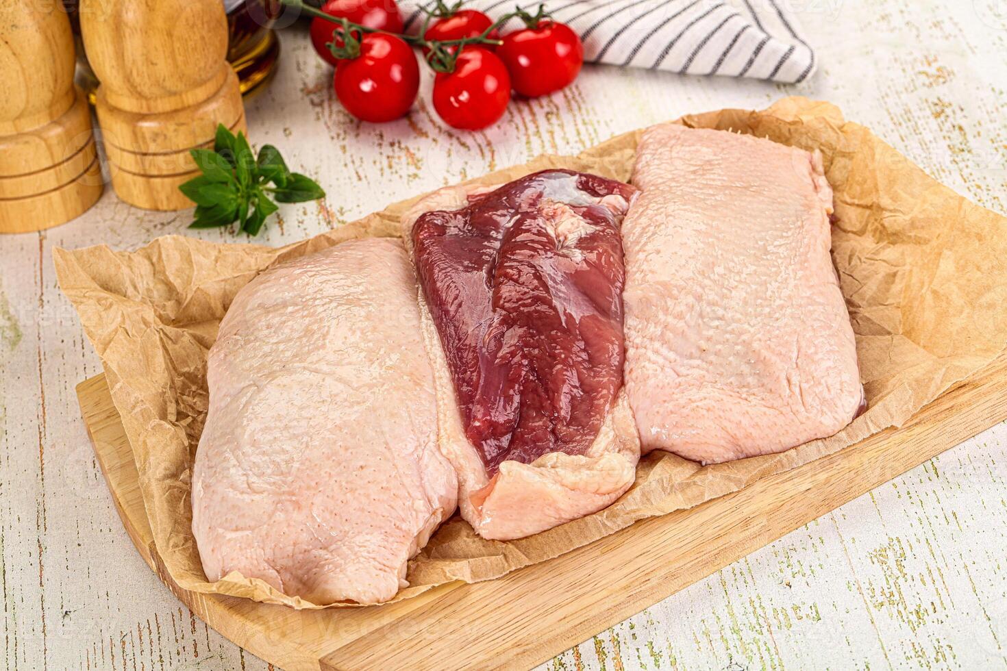 Two raw chicken breasts on a cutting board photo