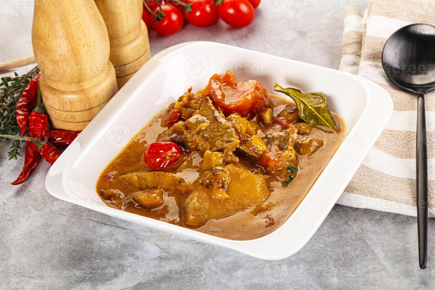 A bowl of food with a spoon and a knife photo
