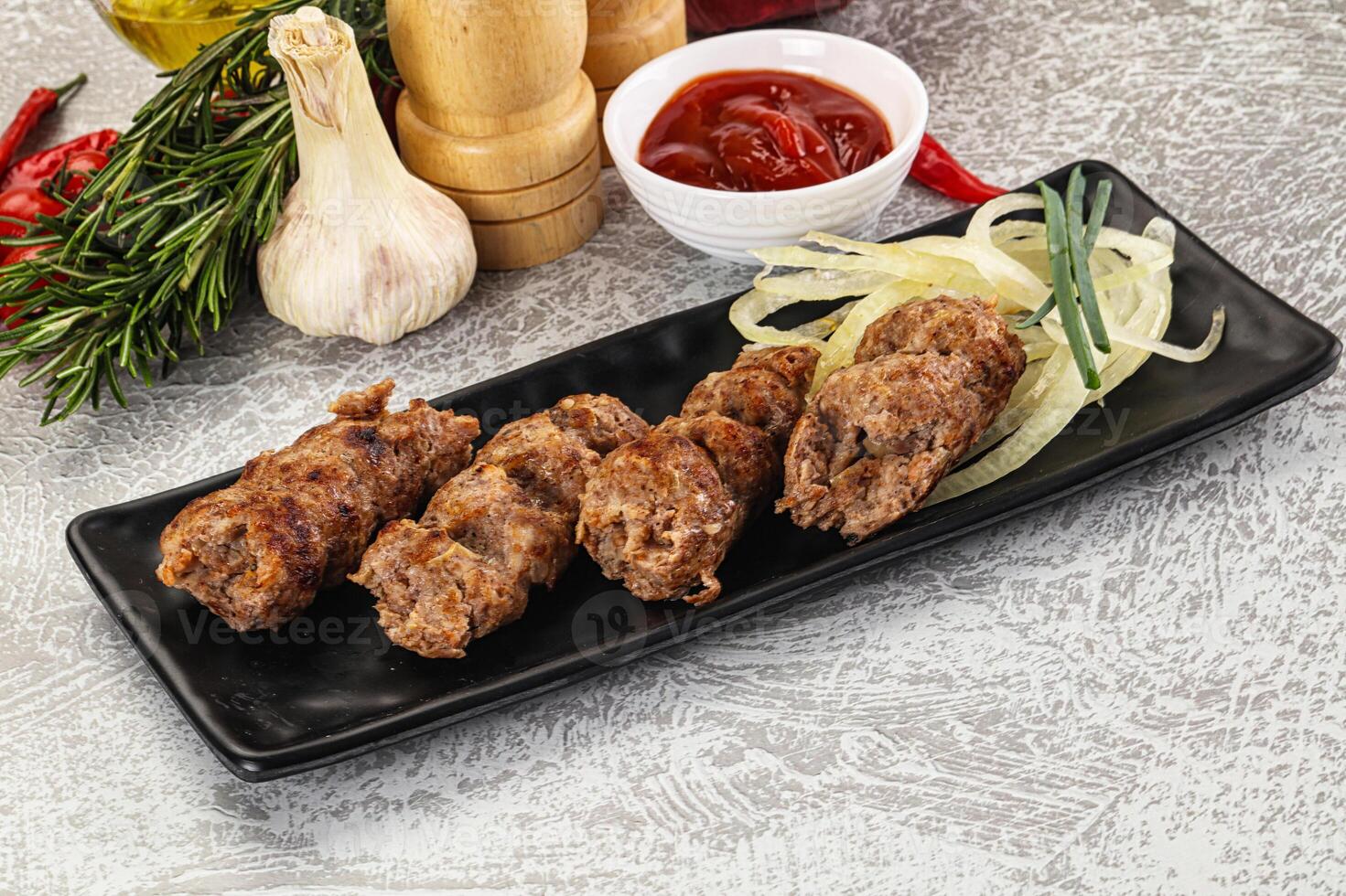 A black plate with meat and vegetables on it photo