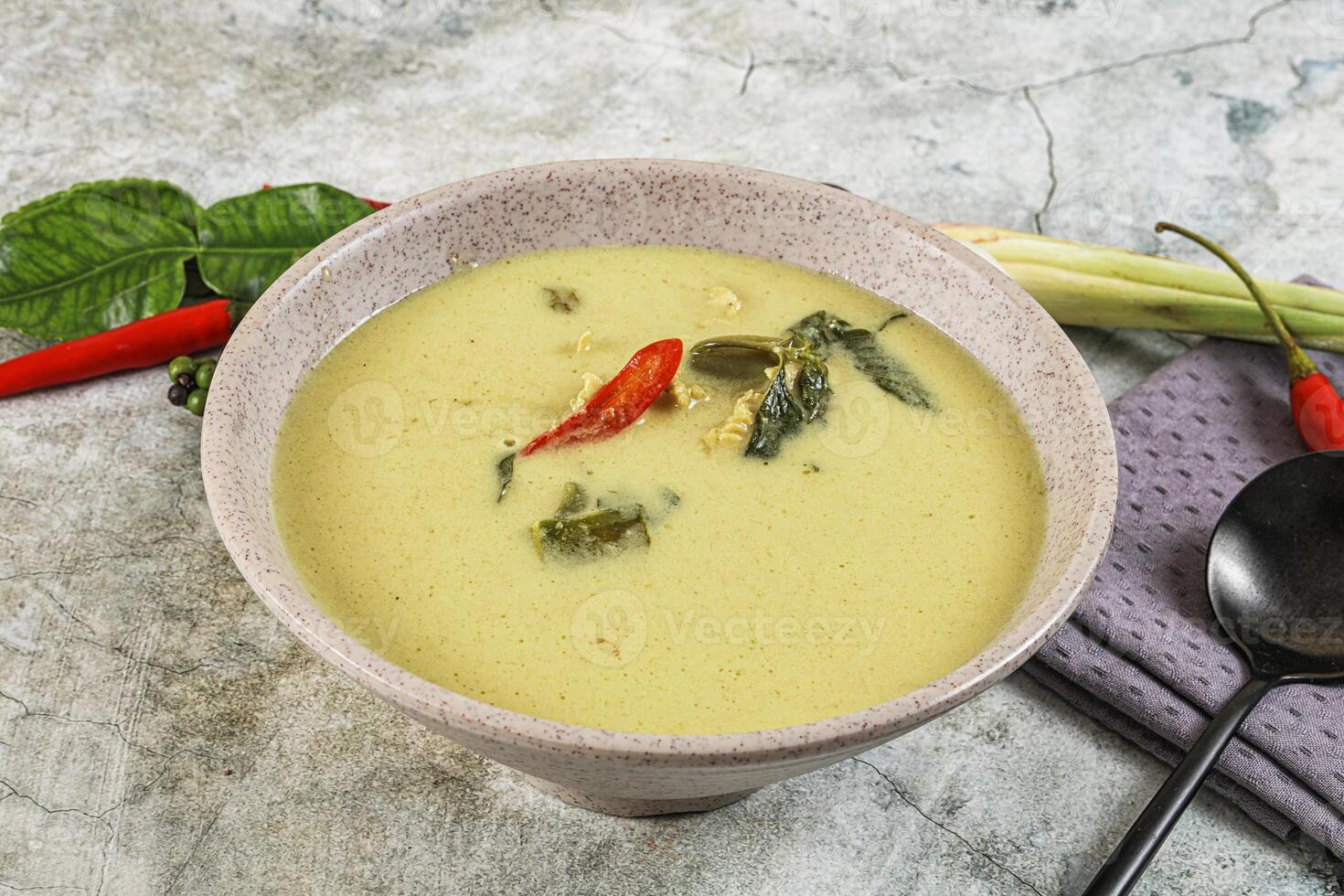 A bowl of soup with a spoon and a napkin photo