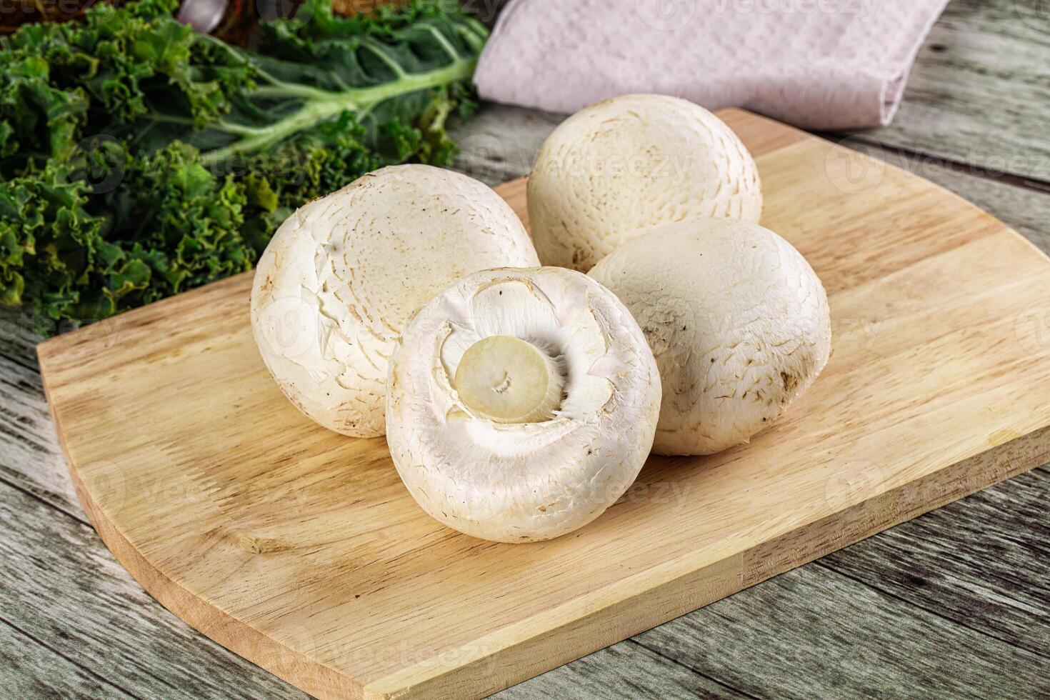 A wooden cutting board with mushrooms and a towel photo