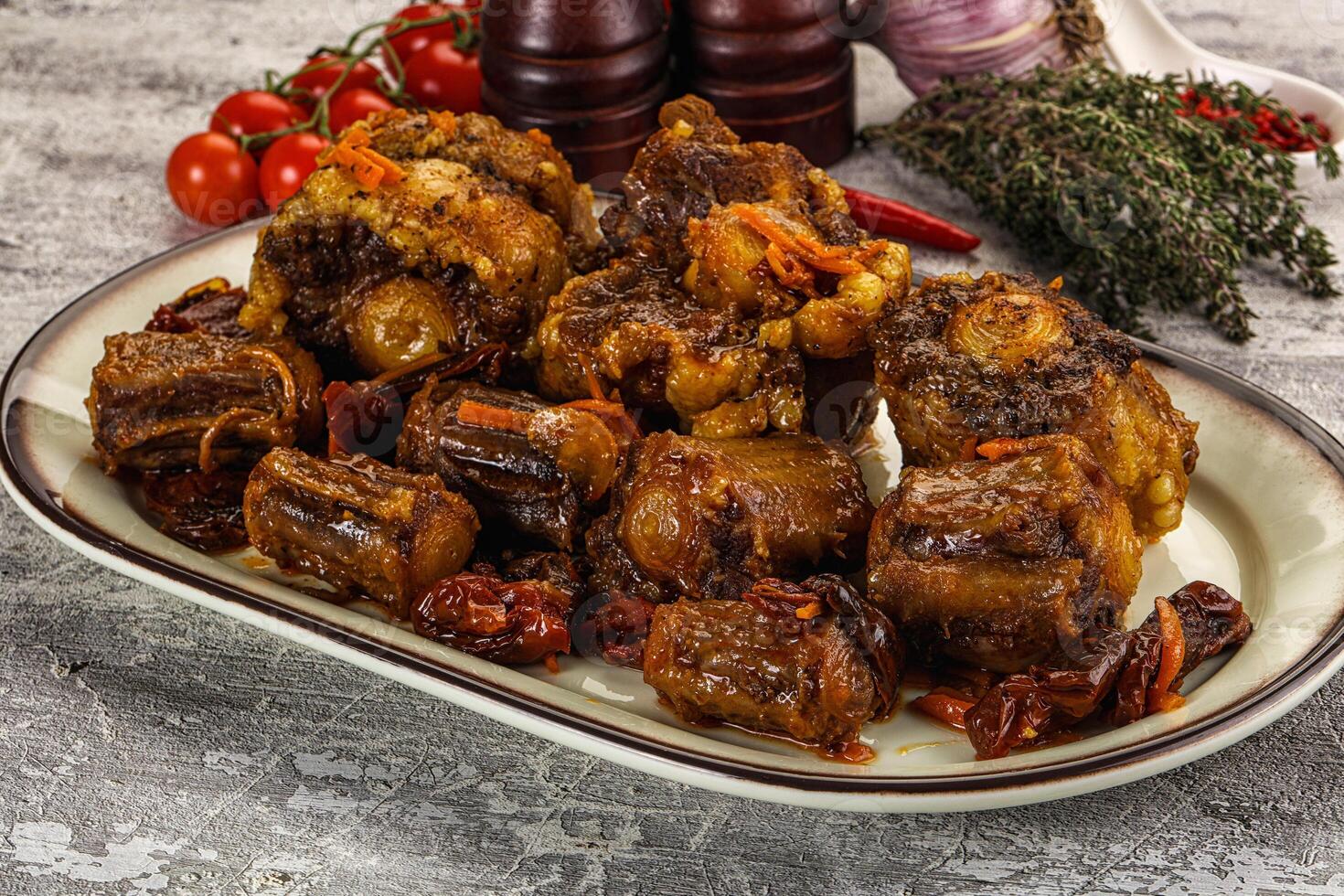 A plate of meat on a table with other ingredients photo