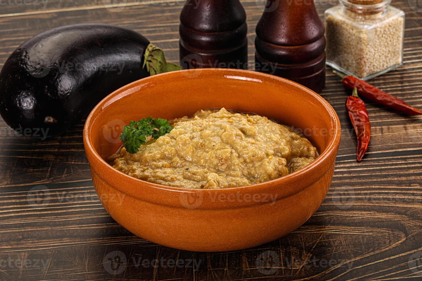 A bowl of food sitting on a table next to a bottle of ketchup photo