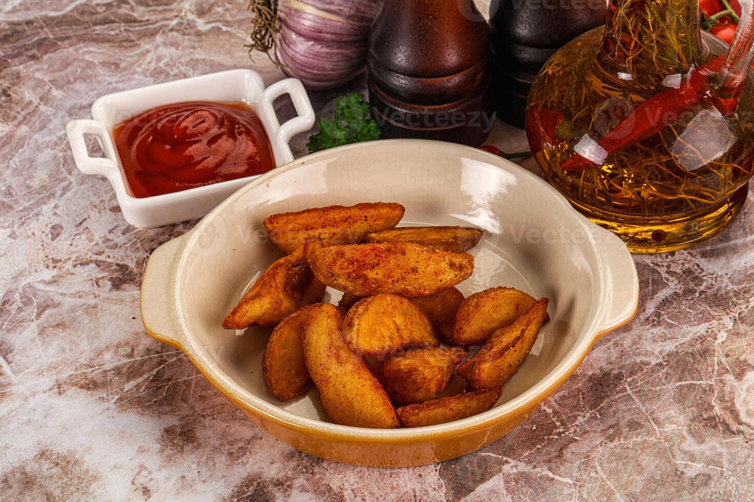 A bowl of potatoes and ketchup on a table photo