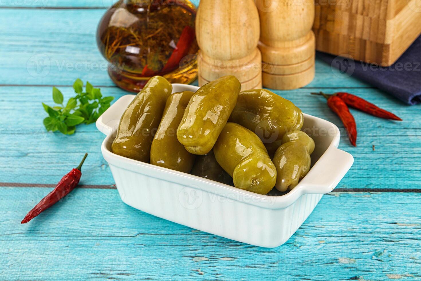 A bowl filled with pickles on a blue table photo