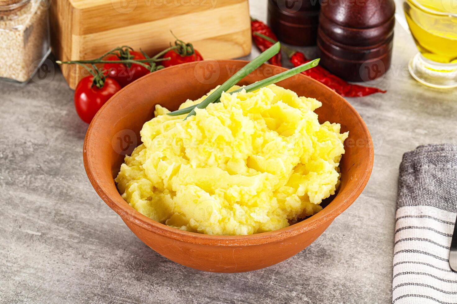 A bowl of mashed potatoes with a green chive photo