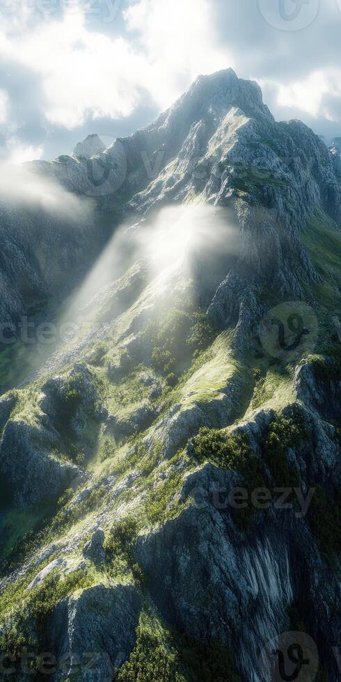 Mountain landscape with sunlight streaming through clouds photo