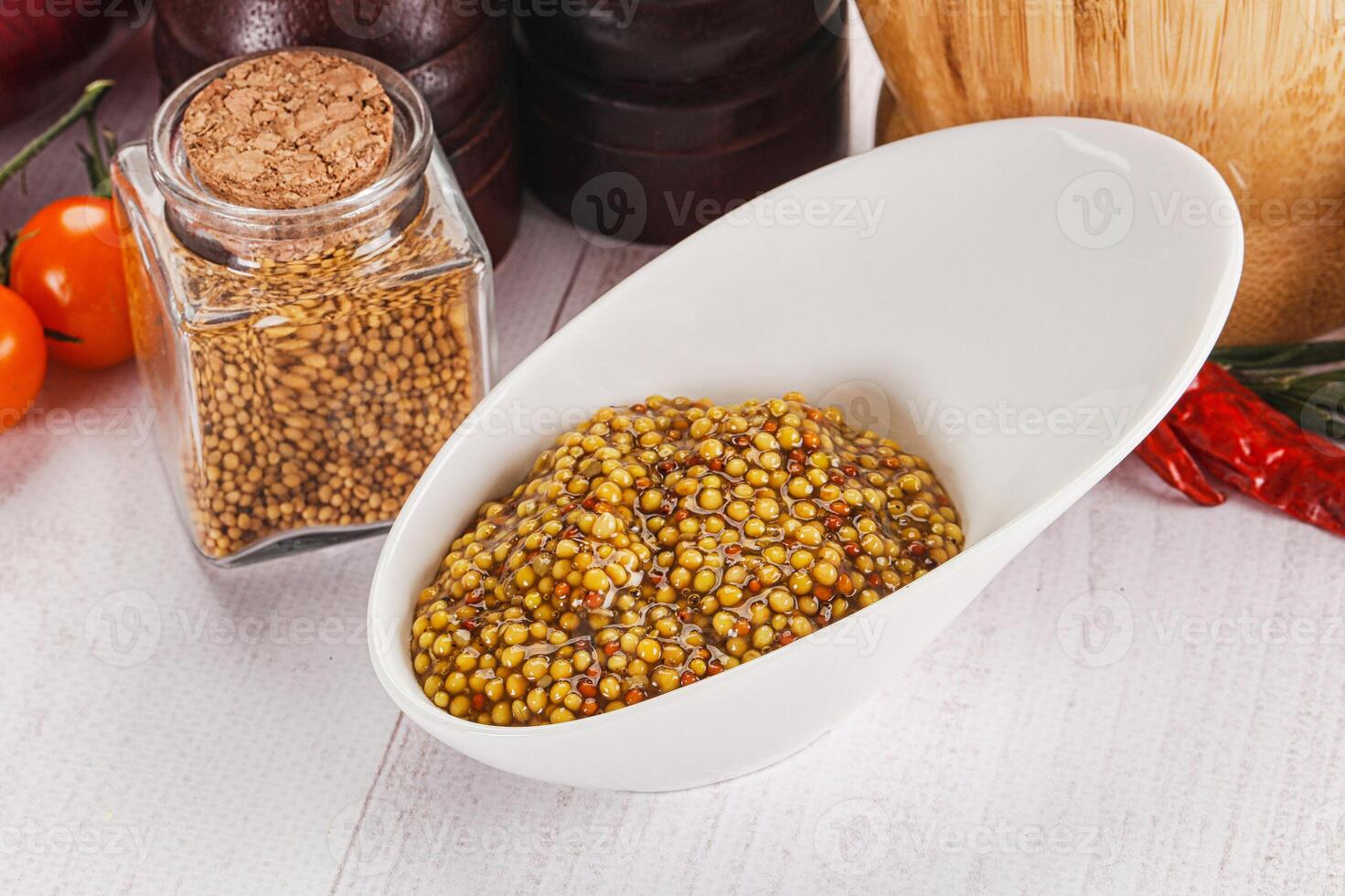 A bowl of mustard and spices on a table photo